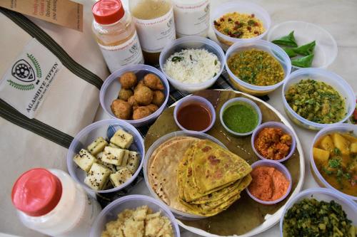a table topped with bowls of different types of food at The House of MG-A Heritage Hotel, Ahmedabad in Ahmedabad