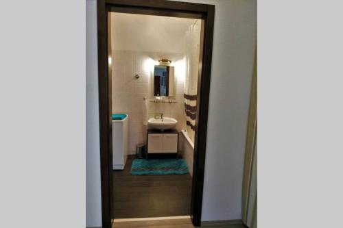 bagno con lavandino e specchio di M&M apartman a Budapest