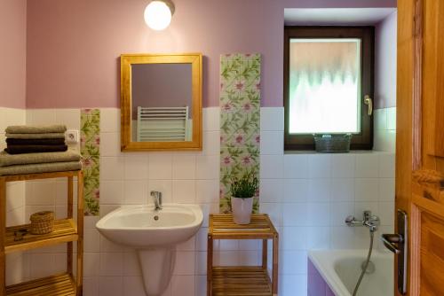 uma casa de banho com um lavatório, um espelho e uma banheira em Refugio em Tisá