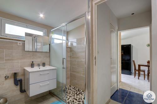 La salle de bains est pourvue d'une douche en verre et d'un lavabo. dans l'établissement Kaz Lendormi - 40 m2 - Piscine - Sainte-Rose, à Cascades
