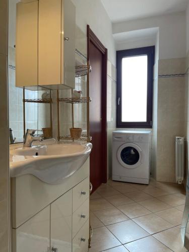 a bathroom with a sink and a washing machine at Casa Gaby in Gravedona