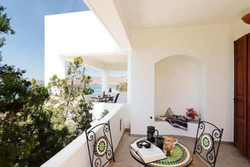 uma varanda com mesa e cadeiras e vista para o oceano em Emerald Dawn Villa em Pefki (Rhodes)