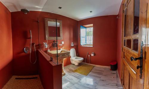 an orange bathroom with a toilet and a sink at Villa Jasmin in Houmt Souk