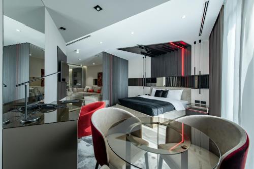 1 dormitorio con 1 cama, mesa de cristal y sillas en Hotel Ženeva Lux en Kragujevac