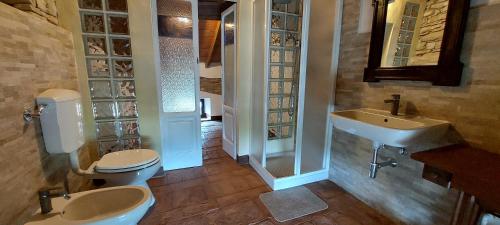 Un baño con dos inodoros y un lavabo. en B&B la Forgia, en Bettola