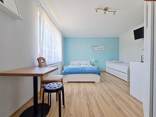 a bedroom with a bed and a desk and a table at Chatka Morska 3 in Karwia