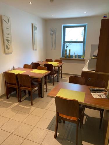 a dining room with tables and chairs and a window at Ho(s)tel Ahrbergen in Giesen