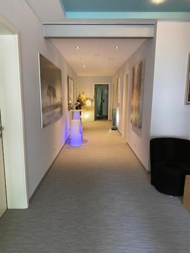 an empty hallway in a building with paintings on the walls at Ho(s)tel Ahrbergen in Giesen
