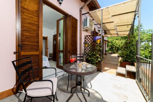 a patio with a table with a glass of wine at B&B Albachiara Casa di Campagna in Ogliastro Cilento