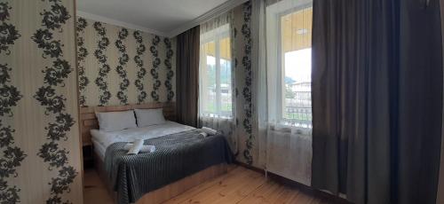 a small bedroom with a bed and a window at Hotel Garbani in Stepantsminda