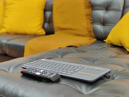 a keyboard and remote control on a leather couch at City Garden Apartments in Bucharest