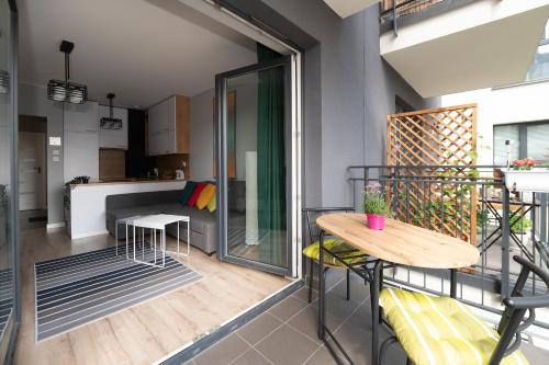 einen kleinen Balkon mit einem Tisch und einer Küche in der Unterkunft Luxury in City -1-Bright-Secured-Free Parking in Łódź