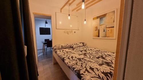 Un pequeño dormitorio con una cama y una mesa. en Secret garden of Piran, en Piran