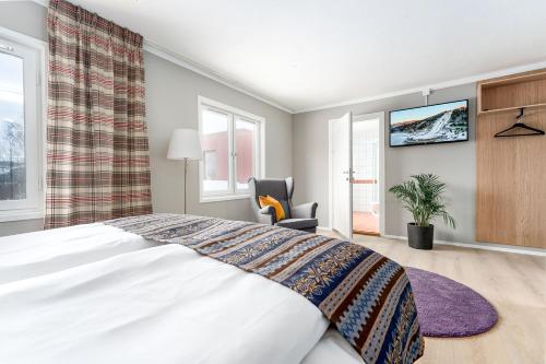 a bedroom with a bed and a tv on the wall at Birkebeineren Hotel & Apartments in Lillehammer
