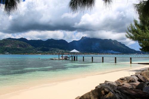 a view of a beach with a pier and the ocean at L'Habitation Cerf Island in Cerf Island