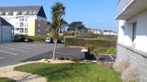 a palm tree in a parking lot next to a building at The Originals City, Hôtel Armen Le Triton, Roscoff in Roscoff