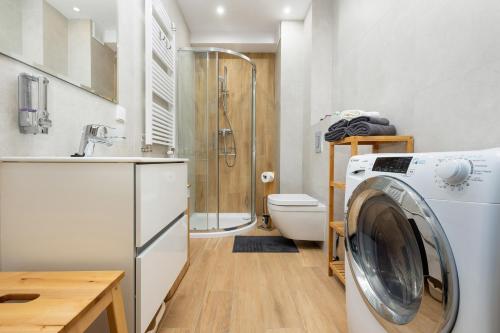 uma máquina de lavar roupa na casa de banho com WC em Apartament Holiday B 104 em Pobierowo