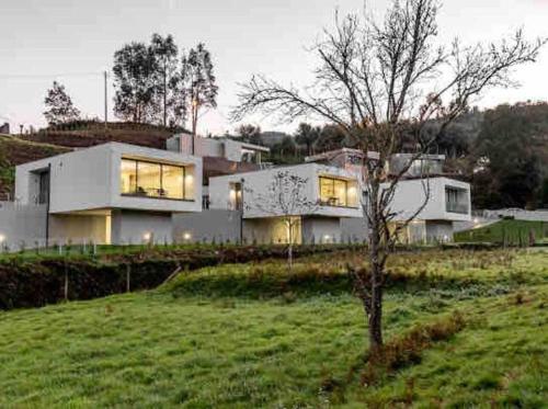 a large white house sitting on top of a lush green field at Viana do Castelo - Amonde Village Casa P - Conforto Qualidade Natureza in Amonde