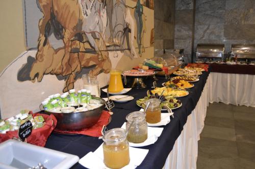 a buffet line with plates of food on it at Pousada de Angra do Heroismo Castelo de S. Sebastiao in Angra do Heroísmo
