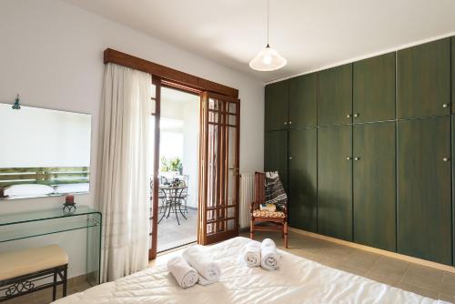 a bedroom with green cabinets and a bed and a balcony at Emerald Dawn Villa in Pefki