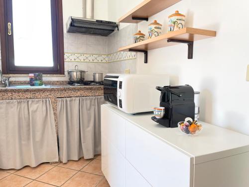 a kitchen with a microwave on top of a counter at La Casetta di Pantelleria in Pantelleria