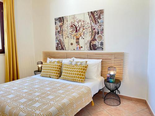 a bedroom with a bed with yellow and white pillows at La Casetta di Pantelleria in Pantelleria