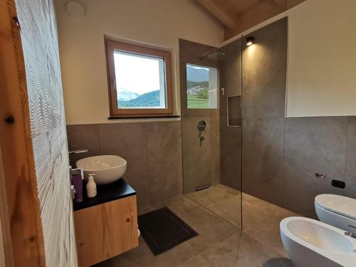 un bagno con due lavandini e una doccia in vetro di Agriturismo Maso Schneider a Cavalese