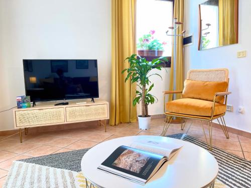 a living room with a tv and a table at La Casetta di Pantelleria in Pantelleria