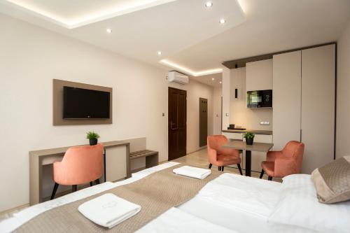 a bedroom with a bed and a table and chairs at Végvár Spa Apartman in Gyula