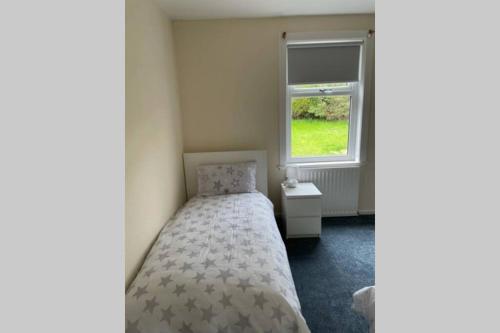 a small bedroom with a bed and a window at Beautiful two bedroom flat by the Loch in Balloch