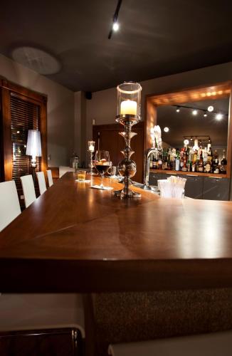 a kitchen with a large wooden table with a light on it at Le Pleasant Hôtel & Café in Sutton