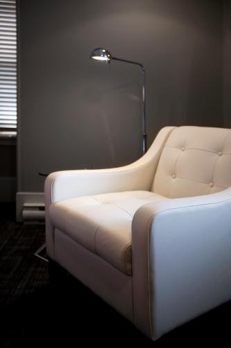 a white couch in a room with a lamp at Le Pleasant Hôtel & Café in Sutton