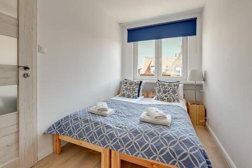 a bedroom with a bed with two towels on it at Lion Apartments - Korfu in Sopot
