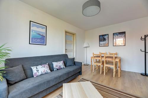 a living room with a couch and a table at Korfu - 200 m from the Beach by Lion Apartments Sopot in Sopot