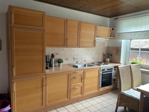 a kitchen with wooden cabinets and a sink at Röhrshof in Bispingen