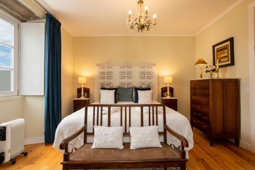 a bedroom with a bed and a chandelier at Tradicampo Eco Country Houses in Nordeste