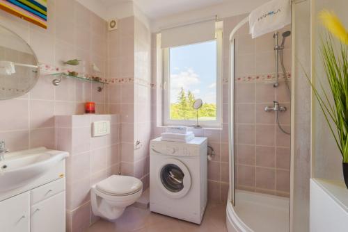 a bathroom with a washing machine and a sink at Apartament Madam in Stegna