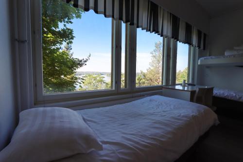 a bedroom with a bed in front of a large window at Varala Nature Hotel & Sport Resort in Tampere