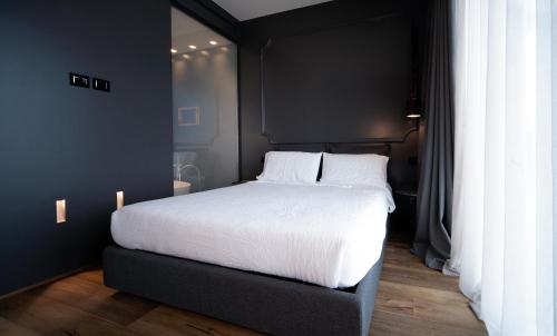 a bedroom with a large bed with white sheets at PICCOLA MAESTA' boutique rooms in Civitanova Marche