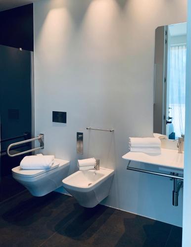 a bathroom with two sinks and a toilet and a mirror at PICCOLA MAESTA' boutique rooms in Civitanova Marche