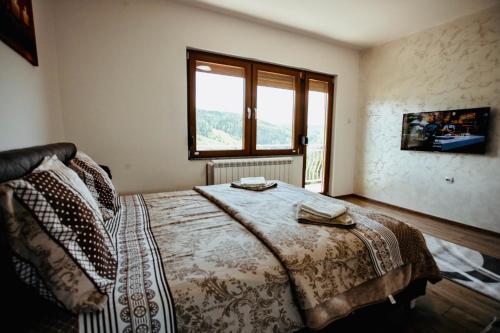 - une chambre avec un lit et une grande fenêtre dans l'établissement Apartmani IN Zlatar, à Nova Varoš