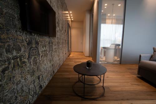a living room with a table and a wall at PICCOLA MAESTA' boutique rooms in Civitanova Marche