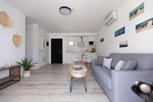 a living room with a blue couch and a table at Island Home Fuerteventura in Corralejo