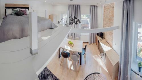 - une chambre avec un grand lit blanc et un bureau dans l'établissement Apartament LUX Cieplice, à Jelenia Góra