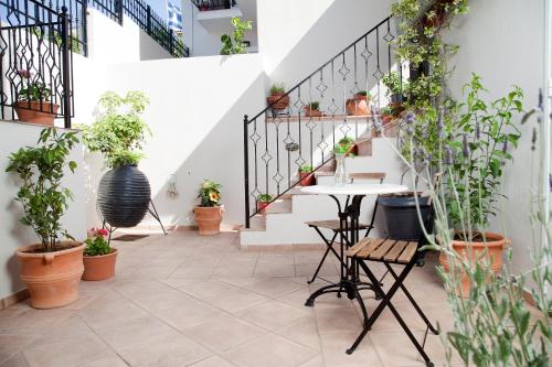 un couloir avec des plantes en pot sur les escaliers dans l'établissement KIMIA Guest House, à Skiathos Chora