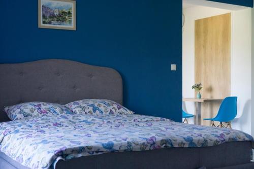 a blue bedroom with a bed and a blue wall at Apartments Ena in Trebinje