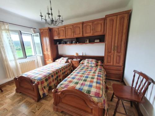 - une chambre avec 2 lits et une armoire en bois dans l'établissement Casa Don Diego, à Perlora