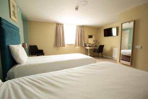 a hotel room with two beds and a desk at The Bridge House; BW Signature Collection in Ferndown