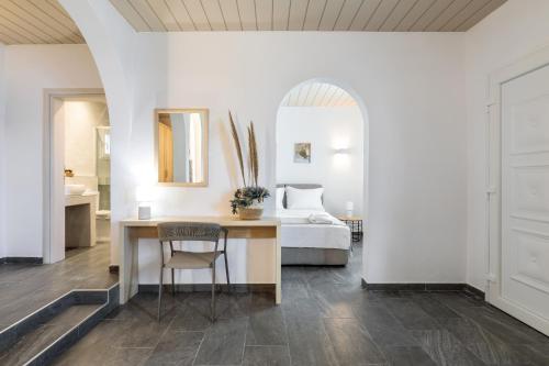 a bedroom with a bed and a table with a chair at Bay View Suites in Agios Nikolaos