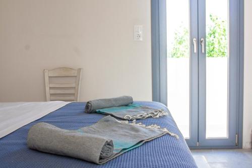a bedroom with a bed with blue sheets and pillows at Orkeli casa in Plaka